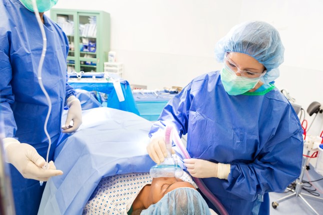 Anesthesiologist working with surgeon to sedate patient before surgery